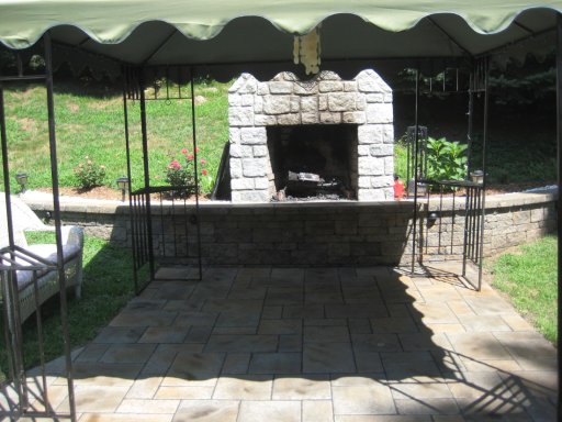Patio by retaining wall with outdoor fireplace